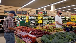 Customers shop for produce at a supermarket