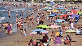 People enjoy the sun and the warm weather at the Segur de Calafell Beach in Spain, where beta cases are rising.