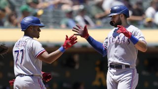 Texas Rangers' Joey Gallo, right, is congratulated by Andy Ibanez, left, after hitting a two-run home run during the fifth inning of a baseball game against the Oakland Athletics in Oakland, Calif., Thursday, July 1, 2021.