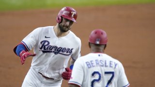 Texas Rangers' Joey Gallo, left, celebrates his solo home run with third base coach Tony Beasley (27) in the second inning of a baseball game against the Detroit Tigers in Arlington, Texas, Wednesday, July 7, 2021.