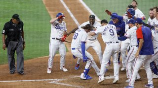 Jonah Heim #28 of the Texas Rangers celebrates with teammates after hitting a two -run walk-off home run to defeat Seattle Mariners 5-4 in ten innings at Globe Life Field on July 31, 2021 in Arlington, Texas.