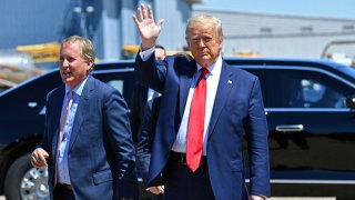 US President Donald Trump waves upon arrival, alongside Attorney General of Texas Ken Paxton (L) in Dallas, Texas, on June 11, 2020, where he will host a roundtable with faith leaders and small business owners.