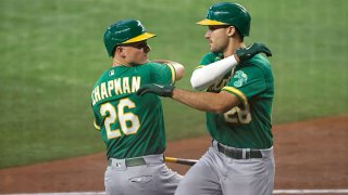 Matt Chapman #26 of the Oakland Athletics celebrates with teammate Matt Olson #28 after Olson hit a solo home run against the Texas Rangers during the fourth inning at Globe Life Field on July 11, 2021 in Arlington, Texas.