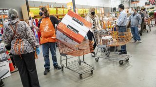 Customers wearing protective masks wait to check out at a Home Depot store in Pleasanton, California, U.S., on Monday, Feb. 22, 2021.