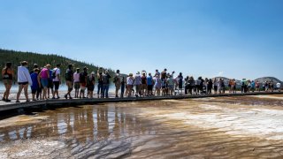 Tourists crowd in to the Midway Geyser Basin on July 14, 2021 at Yellowstone National Park, Wyoming. Yellowstone is one of many national parks seeing record numbers of visitors this summer.