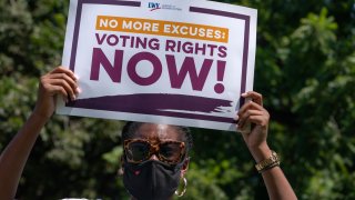 LaQuita Howard of Washington, with the League of Women Voters, attends a rally for voting rights, Tuesday, Aug. 24, 2021, near the White House in Washington.
