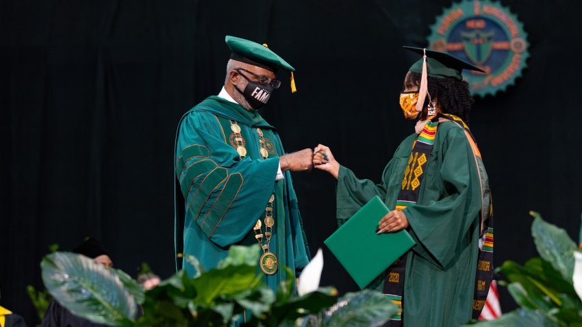 Tallahassee, FL – Florida A&M University’s President Dr. Larry Robinson is seen bumping fists with a graduate at the HBCU’s commencement ceremony on Saturday, July 31, 2021.