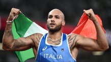 Italy's Lamont Jacobs holds his national as he celebrates winning the men's 100m final during the Tokyo 2020 Olympic Games at the Olympic Stadium in Tokyo on Aug. 1, 2021.