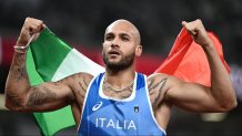 Italy's Lamont Jacobs holds his national as he celebrates winning the men's 100m final during the Tokyo 2020 Olympic Games at the Olympic Stadium in Tokyo on Aug. 1, 2021.