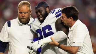 Defensive tackle Neville Gallimore #96 of the Dallas Cowboys is helped by trainers after an injury in the second half of the NFL preseason game against the Arizona Cardinals at State Farm Stadium on Aug. 13, 2021 in Glendale, Arizona.