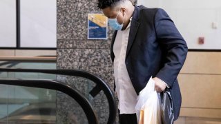 Jonathan Pitts walks off the escalator after visiting the pre-trial services office on Monday, Aug. 16, 2021, at the Frank Crowley Courts Building in Dallas. Pitts, a murder suspect scheduled to go on trial this week, was released from Dallas County jail after it was revealed that the city may have lost evidence in his case.