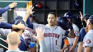 Carlos Correa #1 of the Houston Astros is greeted in the dugout in the third inning after a solo home run against the Texas Rangers at Globe Life Field on Aug. 28, 2021 in Arlington, Texas.