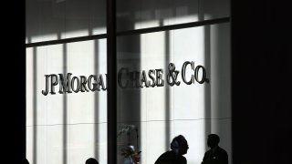 People pass a sign for JPMorgan Chase at its headquarters in New York City.