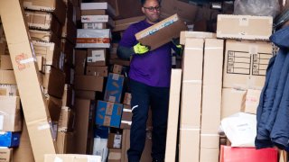 An independent contractor to FedEx Corp. unloads packages from a delivery truck on Cyber Monday in New York, U.S., on Monday, Dec. 2, 2019.