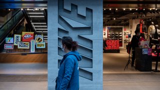 A pedestrian walks past American multinational sport clothing brand, Nike store and its logo seen in Hong Kong.