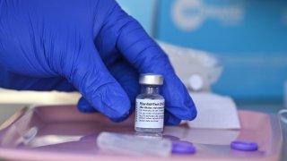 A nurse reaches for a vial of Pfizer-BioNTech Covid-19 vaccine