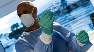 Doctor Immanuel Hardtmann holds a syringe with the vaccine Moderna in a temporary vaccination center inside the Excursion boat Alexander von Humboldt on the first day of the #HierWirdGeimpft (Get Vaccinated Here) Covid-19 vaccination campaign on September 13, 2021 in Berlin, Germany.