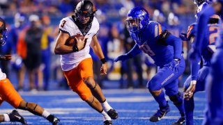 Oklahoma State quarterback Spencer Sanders (3) runs with the ball past Boise State defensive end Demitri Washington (38) during the first half of an NCAA college football game Saturday, Sept. 18, 2021, in Boise, Idaho.