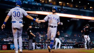 Texas Rangers' Nathaniel Lowe (30) and Nick Solak celebrate after scoring against the Arizona Diamondbacks during the eighth inning of a baseball game Wednesday, Sept. 8, 2021, in Phoenix.