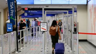 Travelers make their way to a security checkpoint at DFW International Airport.