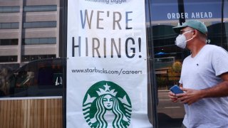 A 'We're Hiring!' sign is posted at a Starbucks on August 06, 2021 in Los Angeles, California. The U.S. economy added over 900,000 jobs in July, the biggest monthly gain since August of last year.