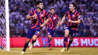 Ricardo Pepi #14 of the United States celebrates after scoring a goal against Honduras during a 2022 FIFA World Cup qualifying game at Estadio Olímpico Metropolitano on September 8, 2021 in San Pedro Sula. Teammate Brenden Aaronson runs alongside him as Cristian Roldan follows behind.