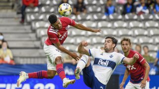 Bryan Acosta #8 of FC Dallas (L) and Brian White #24 of the Vancouver Whitecaps at BC Place on September 25, 2021 in Vancouver, British Columbia.