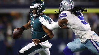ARLINGTON, TEXAS – SEPTEMBER 27: Jalen Hurts #1 of the Philadelphia Eagles tries to outrun the tackle of Jaylon Smith #9 of the Dallas Cowboys during the first half at AT&T Stadium on September 27, 2021 in Arlington, Texas. (Photo by Tom Pennington/Getty Images)