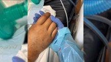 Joey and Lena Rodriguez hold hands in his Mansfield hospital room. She is the only person allowed to visit her husband.