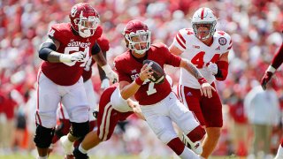 Quarterback Spencer Rattler #7 of the Oklahoma Sooners scrambles for a first down against inside linebacker Luke Reimer #28 and outside linebacker Garrett Nelson #44 of the Nebraska Cornhuskers in the fourth quarter at Gaylord Family Oklahoma Memorial Stadium on Sept. 18, 2021 in Norman, Oklahoma. Oklahoma won 23-16.