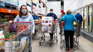Shoppers wearing masks search for items at a Costco Wholesale store
