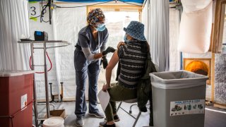 Anjali Sundararaman, a student nurse at San Francisco State University, administers a dose of Moderna COVID-19 vaccine to Cuixia Xu during a vaccination clinic at the Southeast Health Center in the Bayview-Hunters Point neighborhood in San Francisco, California on Monday, Feb. 8, 2021.