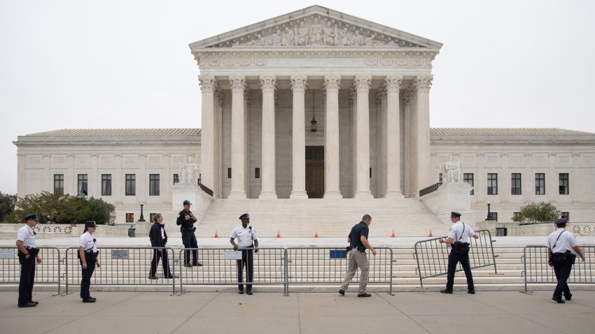 Police officers set up barricades in front of of the U.S. Supreme Court in Washington, D.C., U.S., on Tuesday, Oct. 12, 2021.