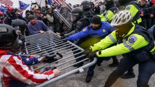 Rioters try to break through a police barrier at the Capitol in Washington.