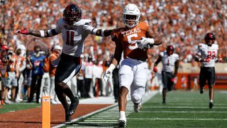 Bijan Robinson #5 of the Texas Longhorns scores a receiving touchdown while defended by Eric Monroe #11 of the Texas Tech Red Raiders in the first quarter at Darrell K Royal-Texas Memorial Stadium on Sept. 25, 2021 in Austin, Texas.