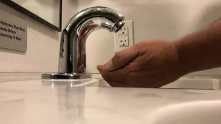A person washes their hands in a sink
