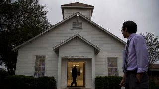 Leonard Favela, right, watches as Ray Sullivan walks into the Sutherland Springs First Baptist Church, which was turned into a memorial, one week after 26 people were killed inside in Sutherland Springs, Texas on Nov. 12, 2017.