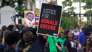 FILE - In this Thursday, May 27, 2021, file photo, demonstrators stand in front of the governor's mansion after a march from the state Capitol in Baton Rouge, La., protesting the death of Ronald Greene, who died in the custody of Louisiana State Police in 2019. A reexamined autopsy ordered up by the FBI in the deadly arrest of Greene has rejected the Louisiana State Police claim that a car crash caused his fatal injuries, narrowing prosecutors’ focus on the troopers seen on body camera video beating, stunning and dragging him.