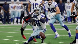 Dallas Cowboys running back Ezekiel Elliott (21) is stripped of the ball by Atlanta Falcons safety Richie Grant, rear, in the second half of an NFL football game in Arlington, Texas, Sunday, Nov. 14, 2021.