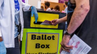 A voter casts a ballot in a drop off box at an early voting polling location for the 2020 Presidential elections in Las Vegas, Nevada, U.S., on Saturday, Oct. 17, 2020. A majority of voters say they’re better off than they were four years ago — but the country overall is worse off, according to a poll released from NBC/Wall Street Journal on Thursday. Photographer: Roger Kisby/Bloomberg via Getty Images