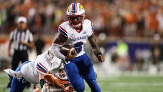 Jalon Daniels #6 of the Kansas Jayhawks runs past Byron Murphy II #90 of the Texas Longhorns in overtime at Darrell K Royal-Texas Memorial Stadium on Nov. 13, 2021 in Austin, Texas.