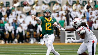Blake Shapen #12 of the Baylor Bears throws a pass under pressure from Devin Drew #90 of the Texas Tech Red Raiders in the second half at McLane Stadium on Nov. 27, 2021 in Waco, Texas. Baylor won 27-24.