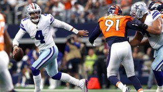 Dak Prescott #4 of the Dallas Cowboys scrambles with the ball as Stephen Weatherly #91 of the Denver Broncos pursues during the first quarter at AT&T Stadium on Nov. 7, 2021 in Arlington, Texas.
