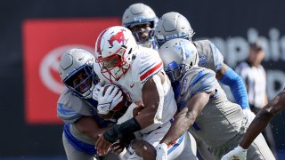 Tre Siggers #4 of the SMU Mustangs is tackled by Xavier Cullens #8 and Jacobi Francis #1 of the Memphis Tigers on Nov. 6, 2021 at Liberty Bowl Memorial Stadium in Memphis, Tennessee. Memphis defeated SMU 28-25.