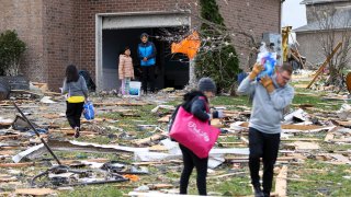 A family whose home was destroyed by a tornado receives water from Angelia and Cameron Miller in Bowling Green, Ky., Saturday, Dec. 11, 2021.