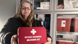 Debra Cross, director of operations for Provoking Hope, an addiction recovery center in McMinnville, Ore., displays an emergency kit used to treat opioid overdose as she stands inside an ambulance converted into a mobile needle-exchange unit. McMinnville and thousands of other towns across the United States that were wracked by the opioid crisis are on the precipice of receiving billions of dollars in the second-biggest legal settlement in U.S. history.