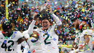 Terrel Bernard #2 of the Baylor Bears holds the Big 12 Championship trophy and celebrates with teammates after Baylor defeated the Oklahoma State Cowboys 21-16 in the Big 12 Football Championship at AT&T Stadium on Dec. 4, 2021 in Arlington, Texas.