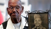 World War II veteran Lawrence Brooks holds a photo of him taken in 1943, as he celebrates his 110th birthday at the National World War II Museum in New Orleans, on Sept. 12, 2019.