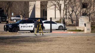 Law enforcement process the scene in front of the Congregation Beth Israel synagogue, Sunday, Jan. 16, 2022, in Colleyville, Texas. A man held hostages for more than 10 hours Saturday inside the temple. The hostages were able to escape and the hostage taker was killed. FBI Special Agent in Charge Matt DeSarno said a team would investigate "the shooting incident."