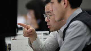 Currency dealers monitor exchange rates in a trading room at KEB Hana Bank in Seoul on March 9, 2020.